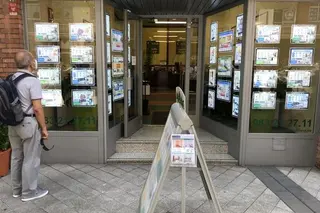 Un señor observa los anuncios de venta y alquiler de viviendas en una inmobiliaria