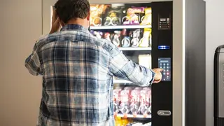 Un hombre en una máquina expendedora. Foto OCU