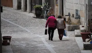 Dos personas caminan en un pueblo de la comunidad