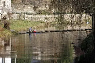 Leticia Pérez / ICAL . Una vecina de Rihonor de Castilla (Zamora) lava la ropa en el río de Onor | Leticia Pérez / ICAL