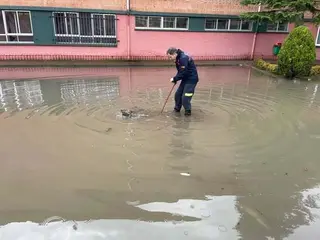 Un miembro del Cuerpo de Bomberos realiza las labores de limpieza para desalojar el agua