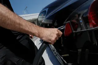Una persona recarga un coche eléctrico EP