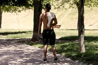 Un chico pasea sin camiseta y con un botellín de agua debido al calor. Europa Press. Archivo