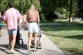 Una pareja pasea a dos bebés